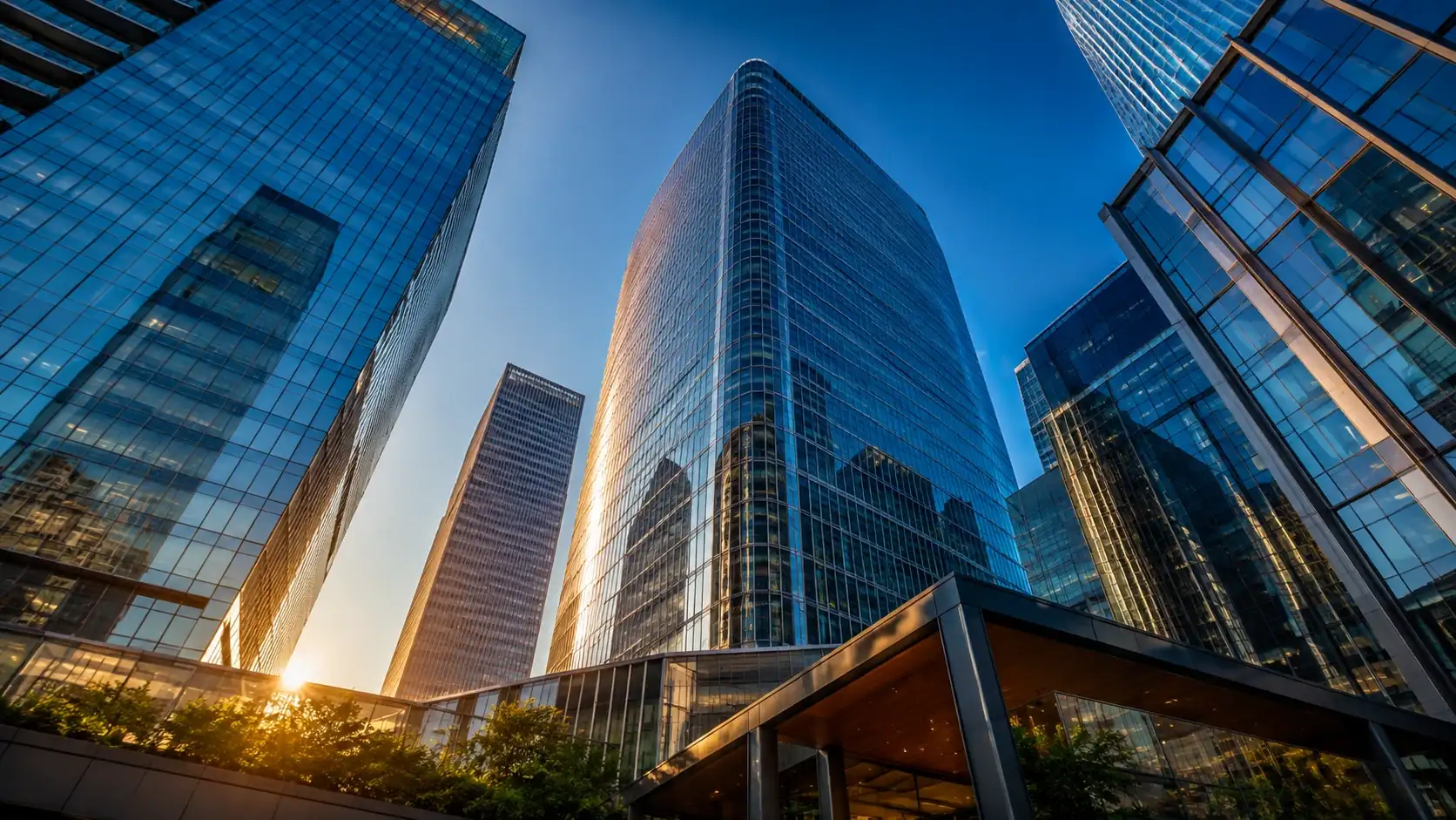 Torres espelhadas de um distrito financeiro vistas do chão, sob céu azul